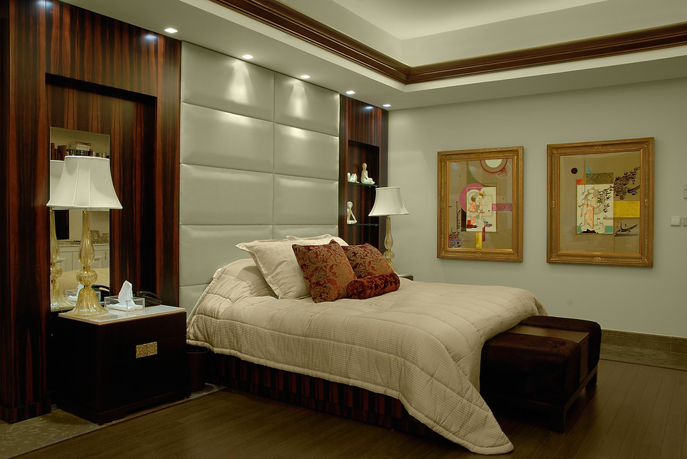 Ejemplo de dormitorio actual con paredes grises y suelo de madera oscura
