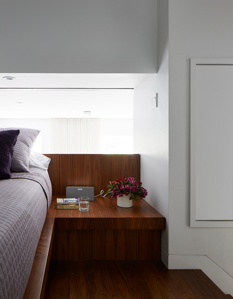Kleines Modernes Schlafzimmer ohne Kamin, im Loft-Style mit weißer Wandfarbe, braunem Holzboden und blauem Boden in New York