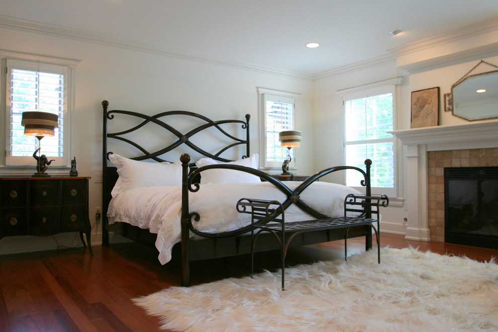 Ejemplo de dormitorio principal contemporáneo grande sin chimenea con paredes blancas y suelo de madera en tonos medios