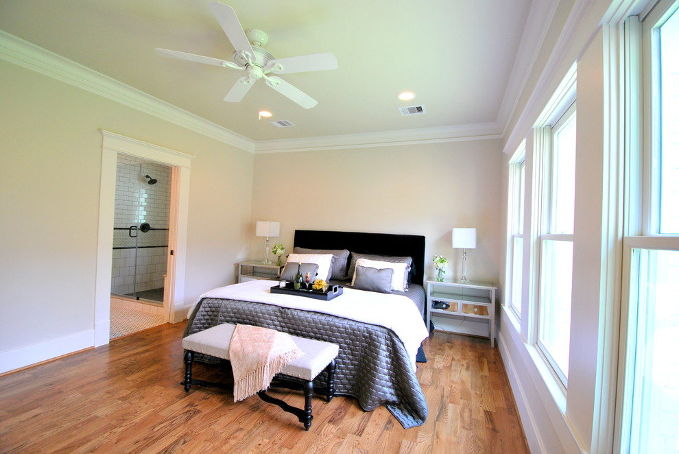 Idée de décoration pour une chambre parentale craftsman de taille moyenne avec un mur beige et un sol en bois brun.
