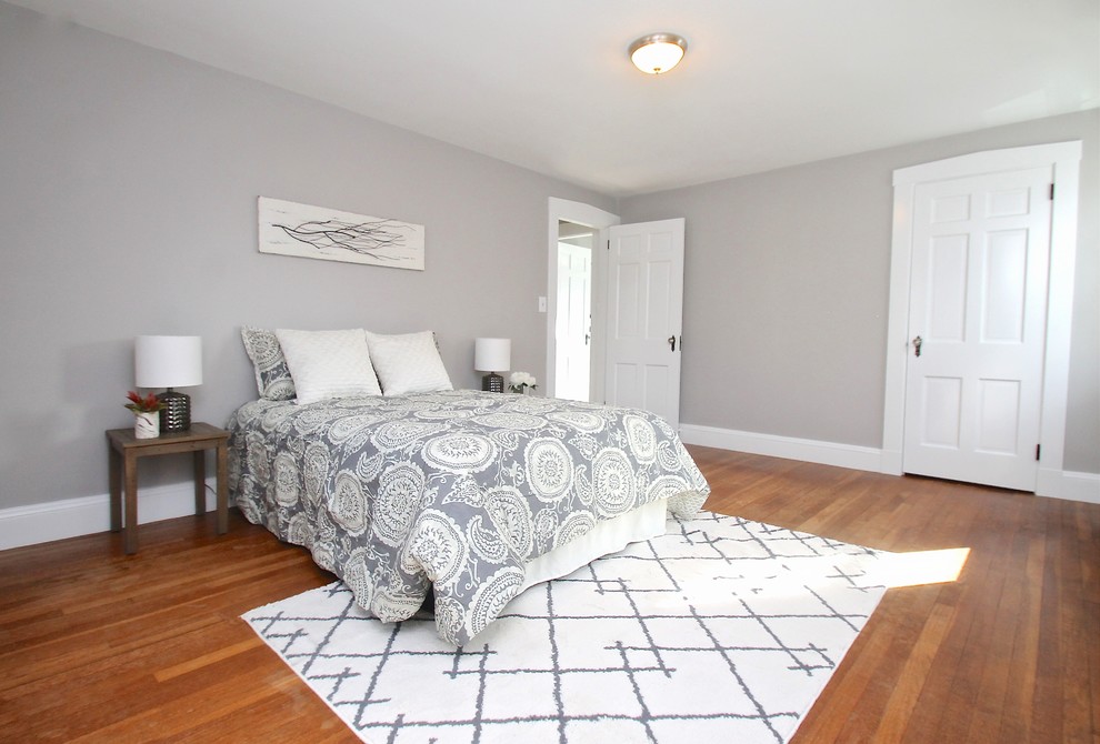 Пример оригинального дизайна: хозяйская спальня среднего размера в стиле неоклассика (современная классика) с серыми стенами, паркетным полом среднего тона и коричневым полом без камина