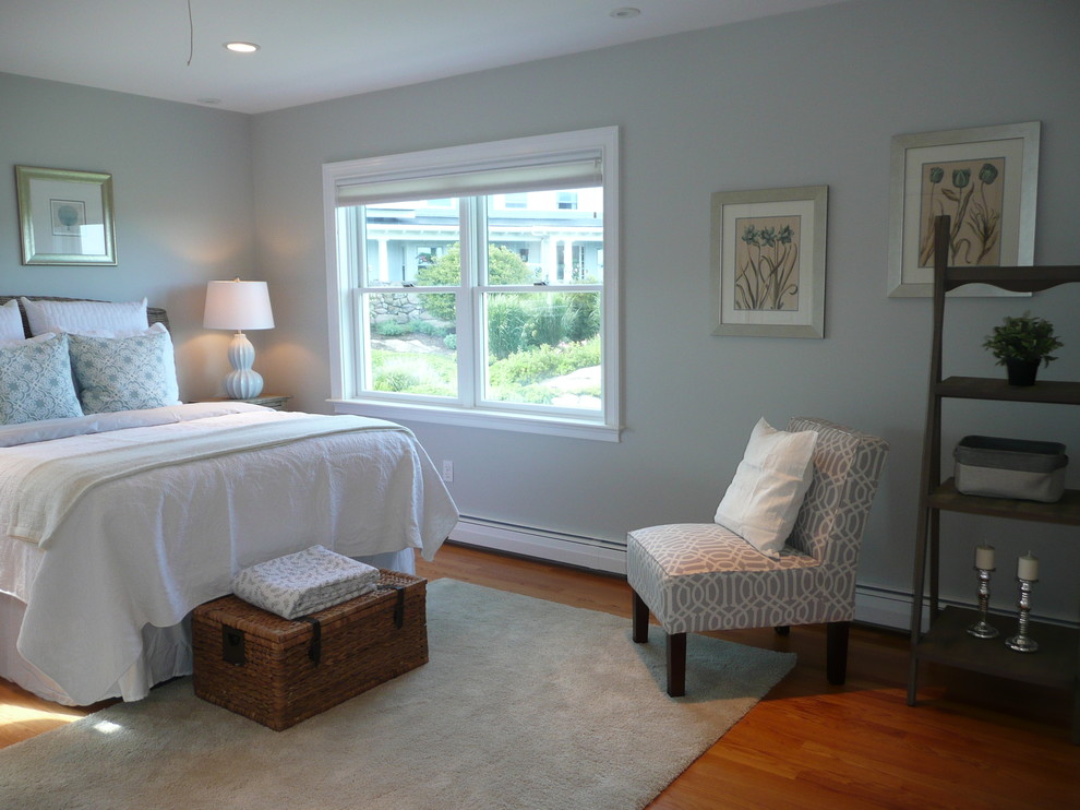 Ejemplo de habitación de invitados costera grande sin chimenea con paredes azules y suelo de madera en tonos medios