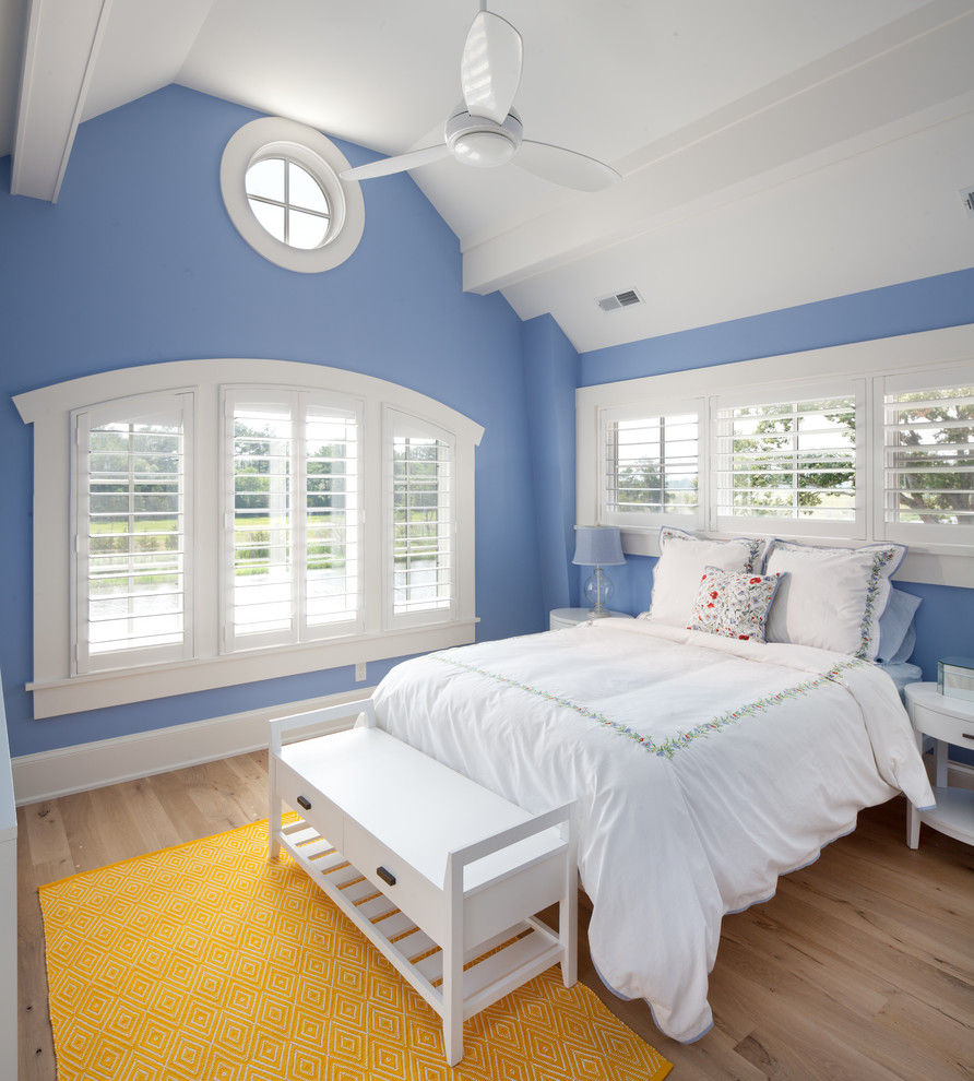 Idee per una camera da letto costiera con pareti blu e pavimento in legno massello medio
