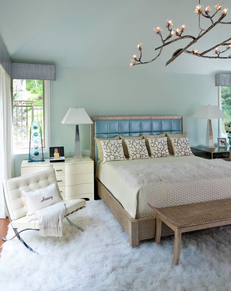 Modelo de dormitorio principal rústico de tamaño medio con paredes azules y suelo de madera en tonos medios