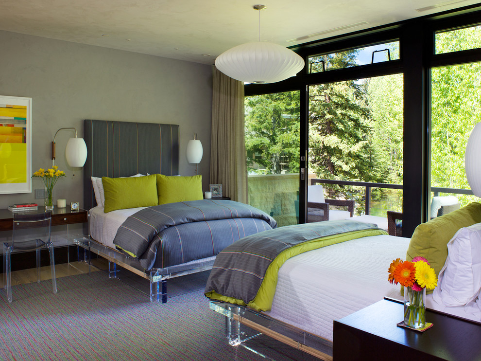 Immagine di una camera da letto design con pareti grigie e parquet chiaro