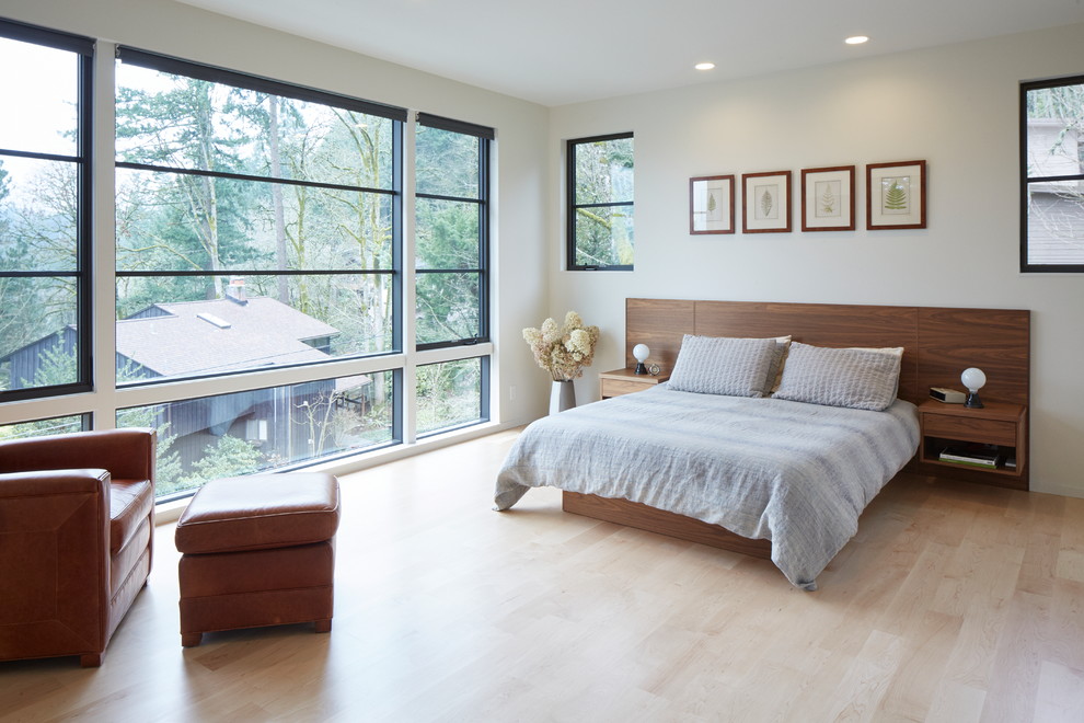 Idée de décoration pour une chambre parentale design de taille moyenne avec un mur blanc, parquet clair et un sol beige.