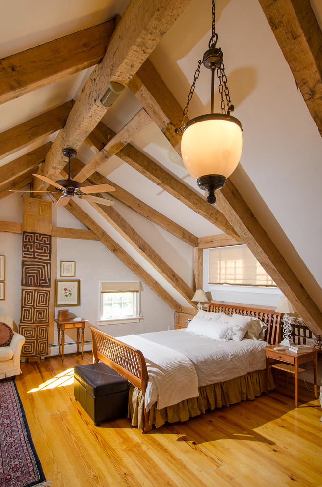 Immagine di una grande camera degli ospiti country con pareti beige e pavimento in legno massello medio