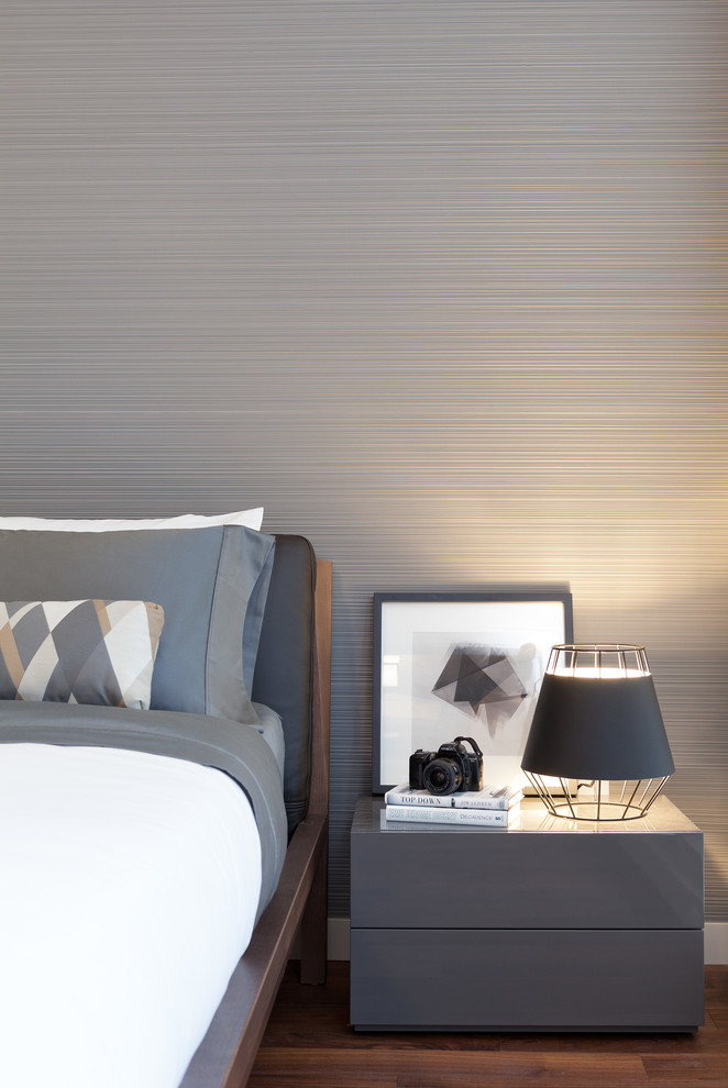 Cette image montre une chambre minimaliste avec un mur gris et un sol en bois brun.