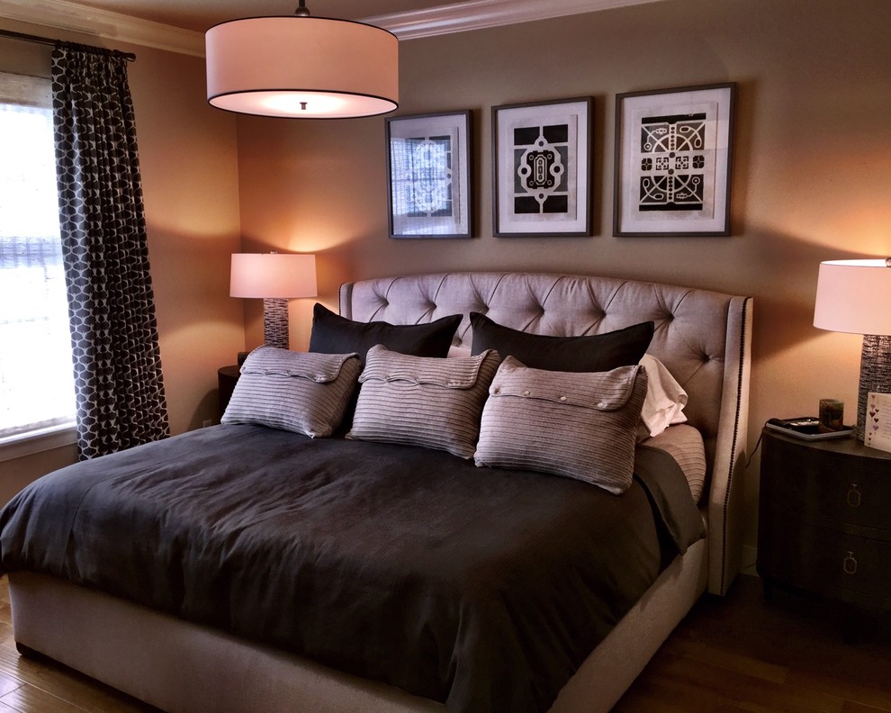 Diseño de dormitorio principal tradicional renovado grande sin chimenea con paredes beige y suelo de madera en tonos medios