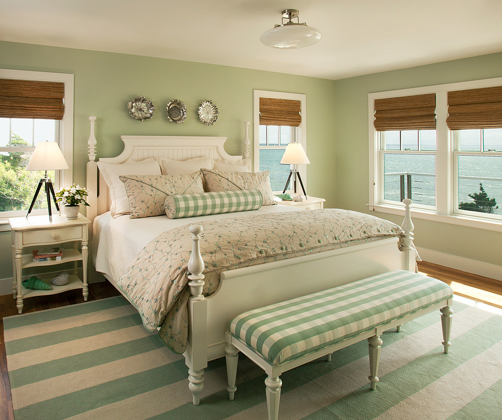 Example of a large beach style medium tone wood floor and brown floor bedroom design in Boston with green walls and no fireplace