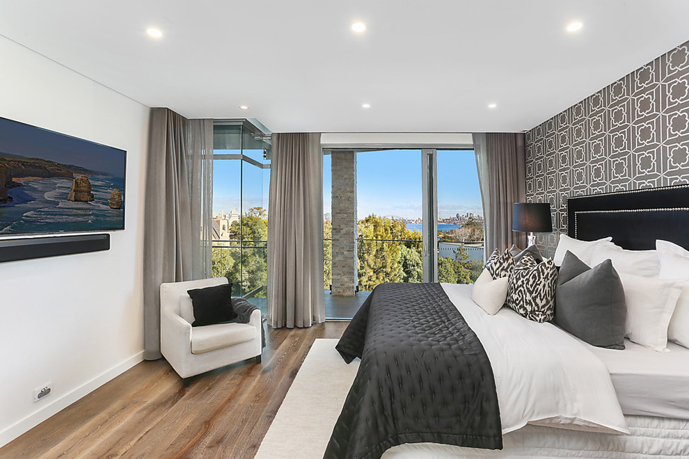 Mittelgroßes Modernes Gästezimmer mit weißer Wandfarbe, braunem Holzboden und braunem Boden in Sydney