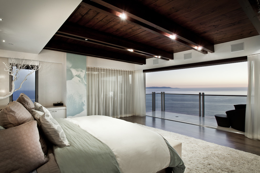 Modernes Schlafzimmer ohne Kamin mit weißer Wandfarbe und dunklem Holzboden in Los Angeles