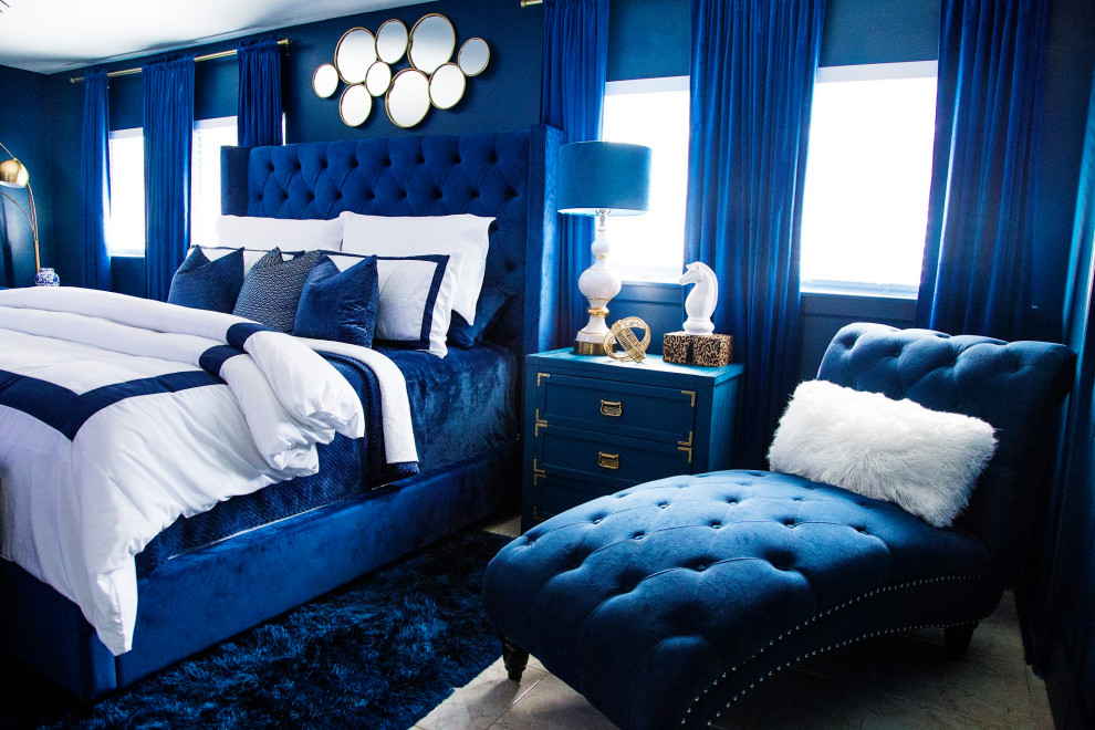 Imagen de dormitorio principal bohemio de tamaño medio con paredes azules, suelo de baldosas de porcelana, chimeneas suspendidas, marco de chimenea de baldosas y/o azulejos y suelo beige