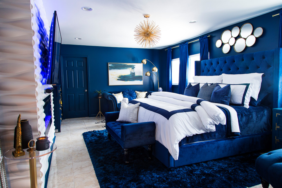 Esempio di una camera matrimoniale bohémian di medie dimensioni con pareti blu, pavimento in gres porcellanato, camino sospeso, cornice del camino piastrellata e pavimento beige