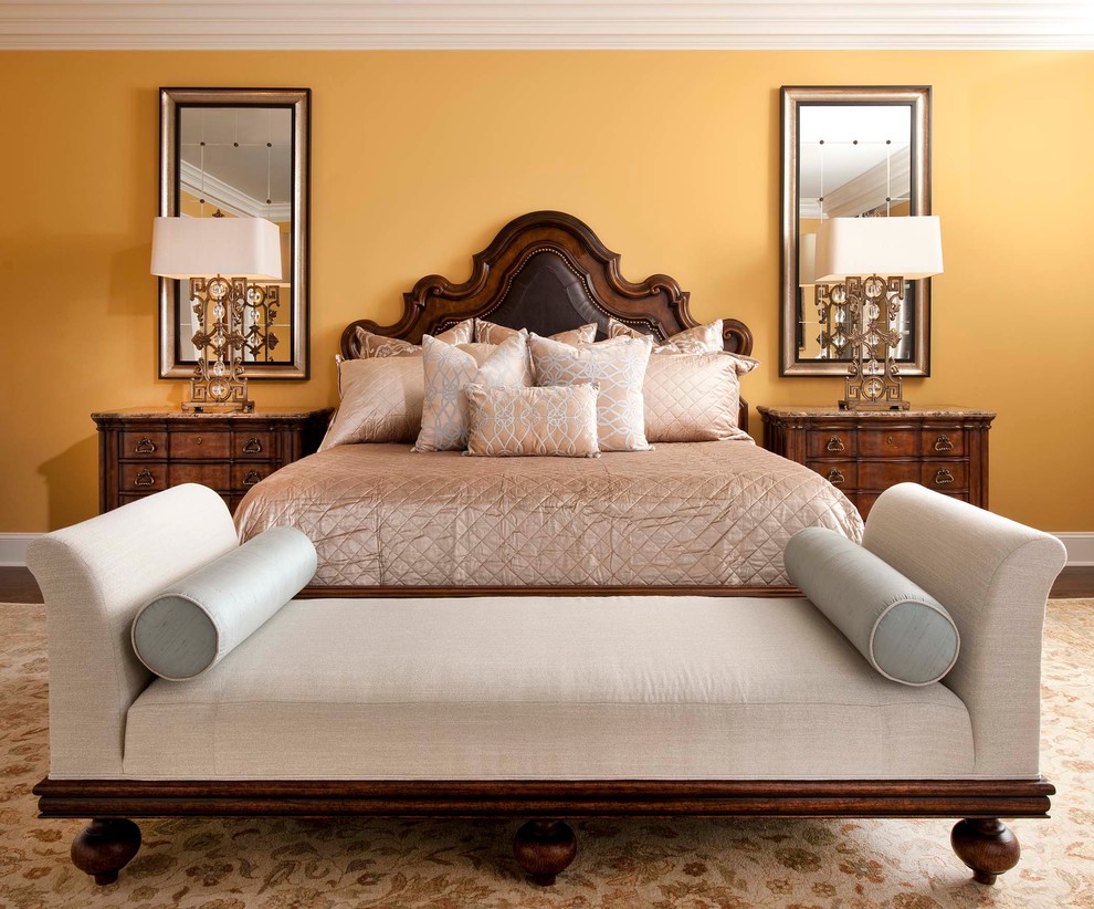 Пример оригинального дизайна: большая хозяйская спальня в средиземноморском стиле с желтыми стенами и темным паркетным полом