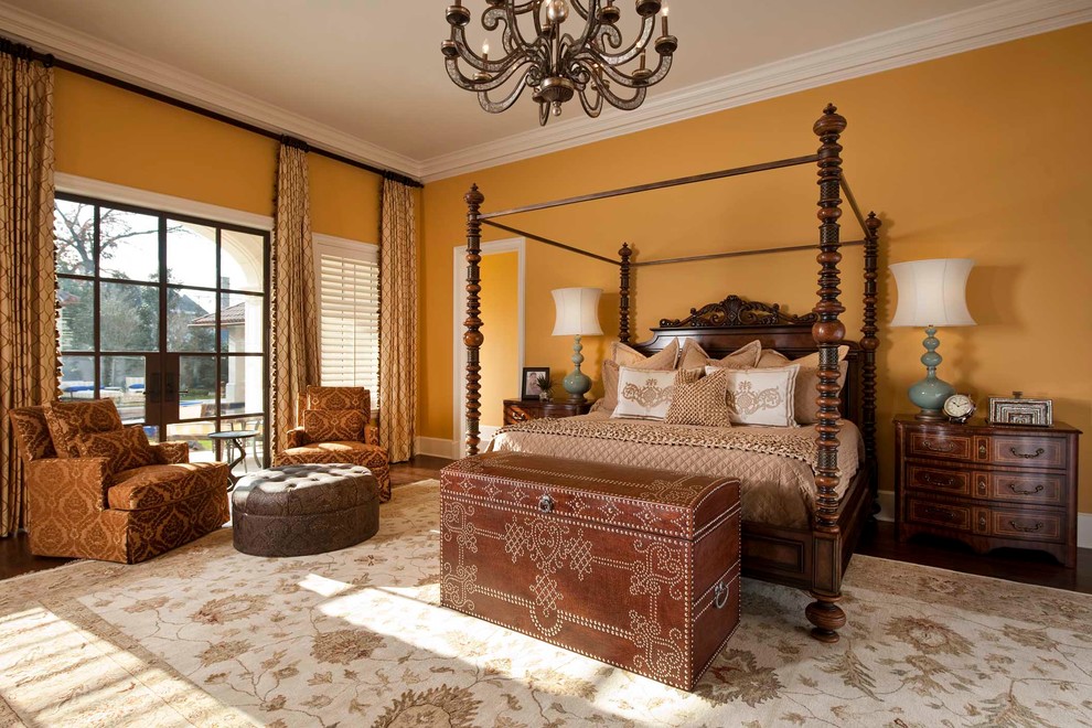 На фото: большая спальня в средиземноморском стиле с желтыми стенами, темным паркетным полом и коричневым полом с