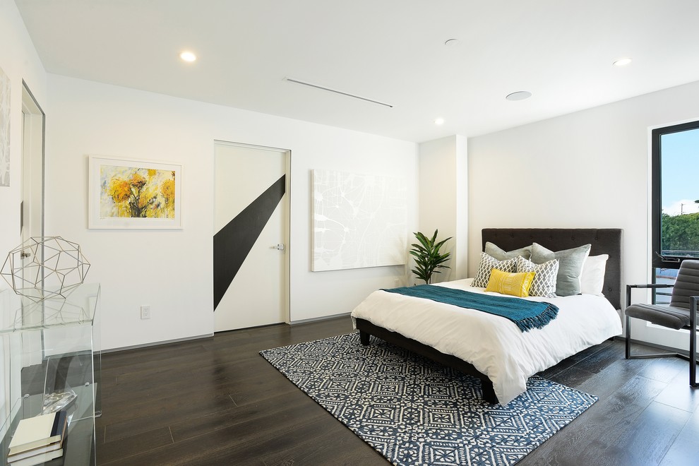 Contemporary bedroom in Los Angeles with white walls and dark hardwood flooring.