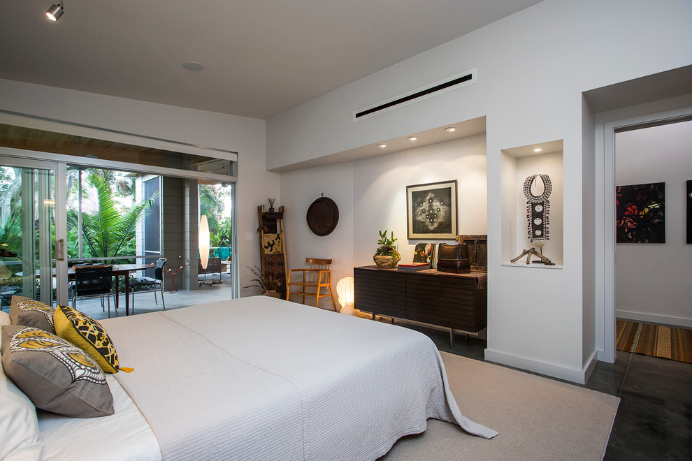Design ideas for a midcentury master bedroom in Tampa with white walls and concrete flooring.