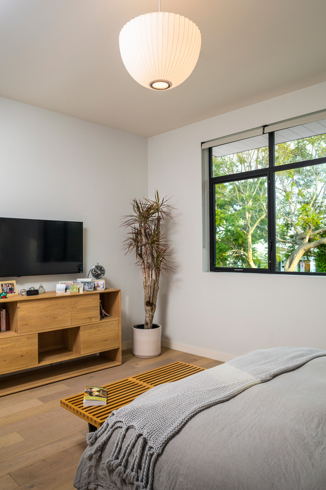 ロサンゼルスにある小さなコンテンポラリースタイルのおしゃれな主寝室 (白い壁、淡色無垢フローリング) のインテリア