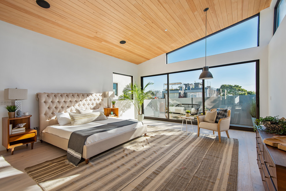 Immagine di una camera da letto design con pareti bianche, pavimento in legno massello medio e pavimento marrone