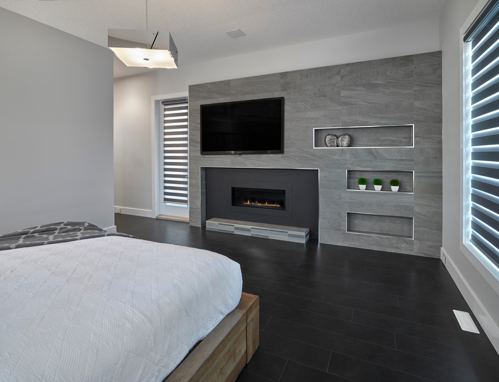 Foto de dormitorio actual con paredes grises, chimenea lineal y marco de chimenea de baldosas y/o azulejos