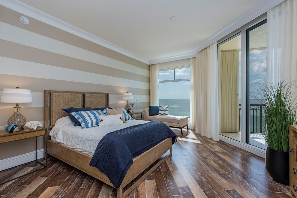 Modelo de dormitorio principal marinero con paredes beige y suelo de madera en tonos medios