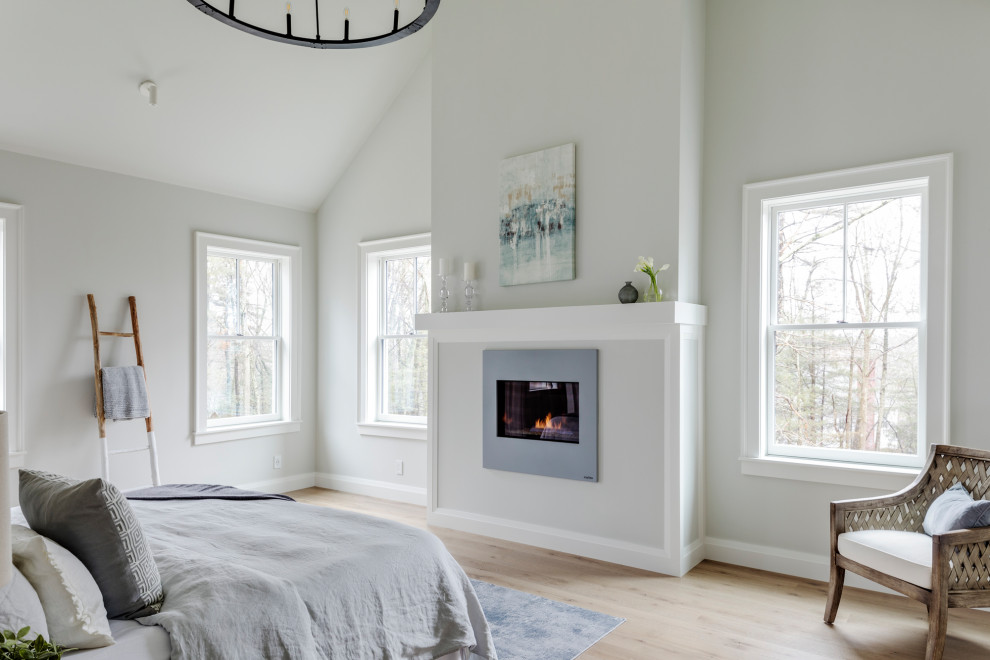 Свежая идея для дизайна: хозяйская спальня среднего размера в стиле кантри с серыми стенами, светлым паркетным полом, стандартным камином и фасадом камина из штукатурки - отличное фото интерьера