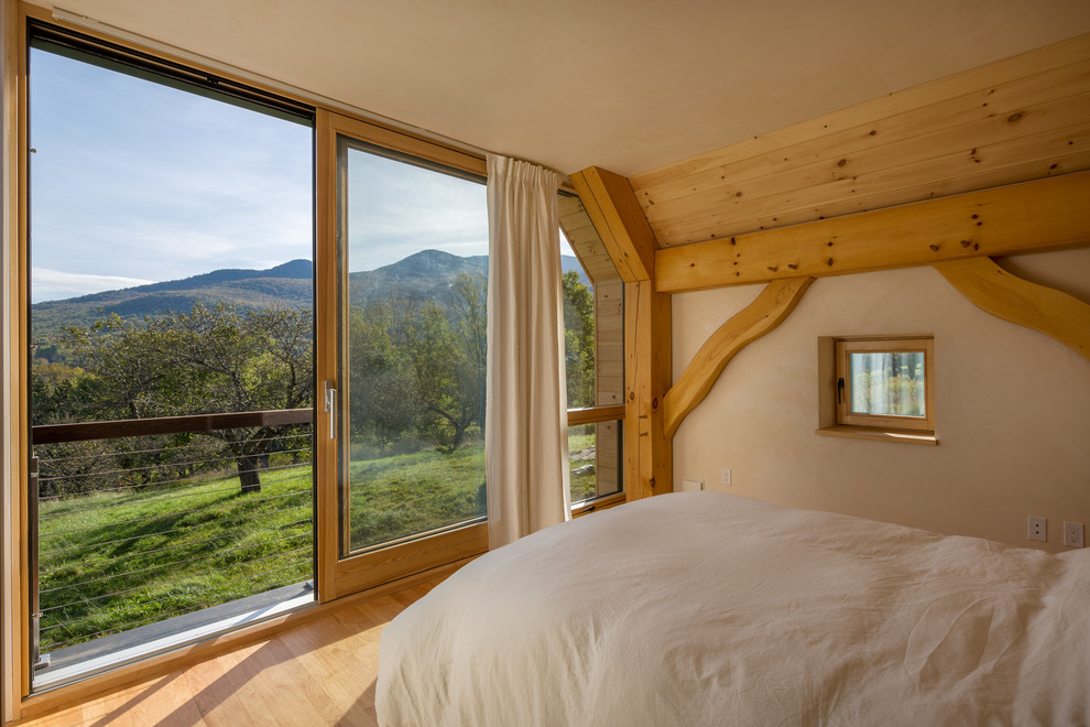 Foto de dormitorio principal rural pequeño con paredes beige, suelo de madera clara y suelo marrón