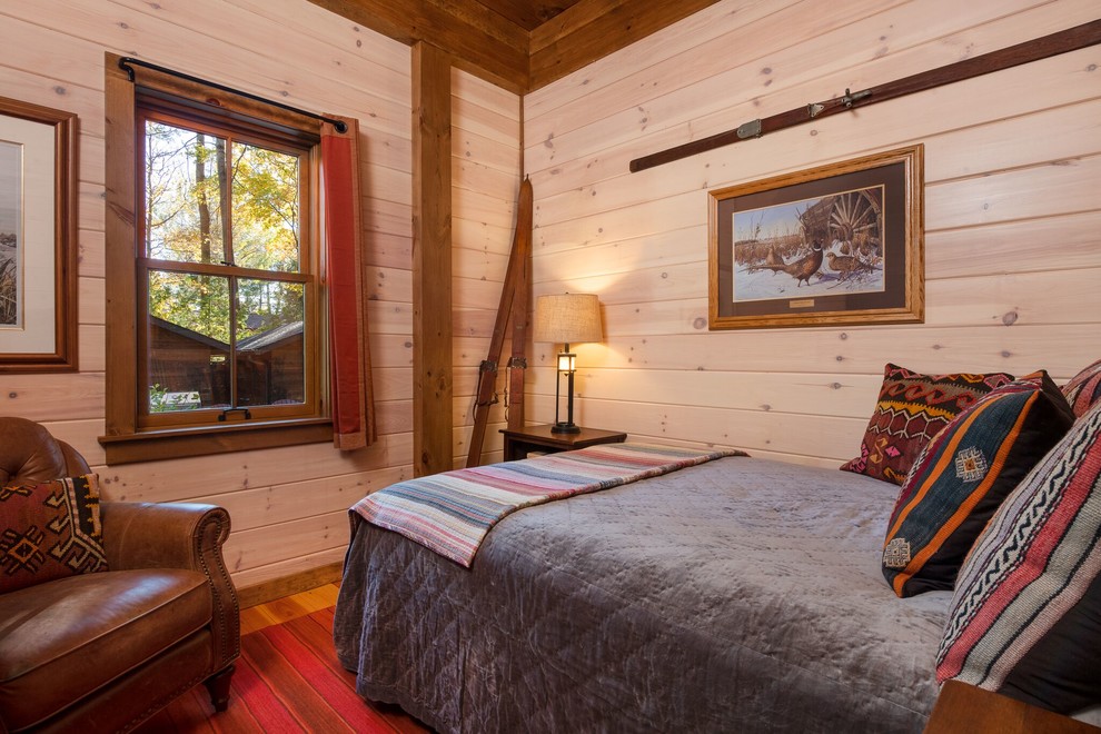 Ejemplo de habitación de invitados rural sin chimenea con paredes beige y suelo de madera en tonos medios