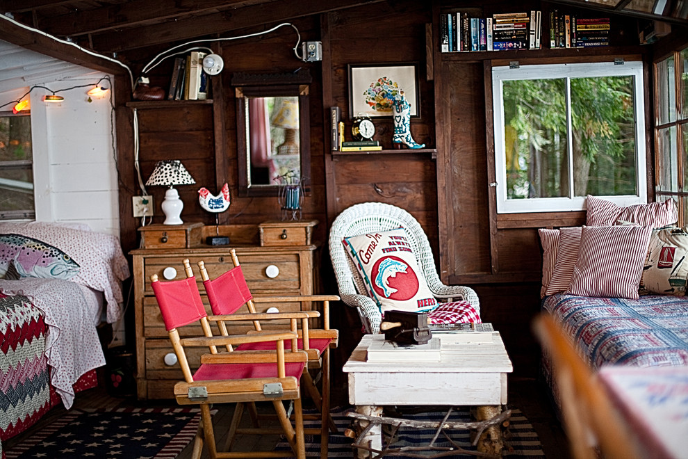На фото: маленькая гостевая спальня (комната для гостей) в стиле рустика с деревянным полом для на участке и в саду с