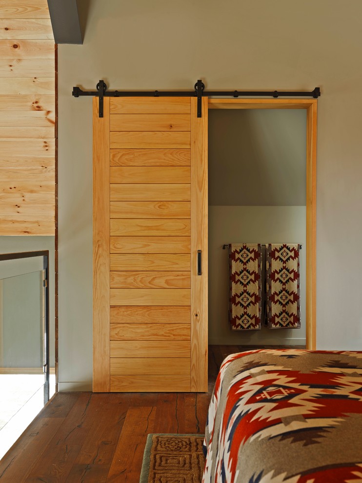 Mittelgroßes Uriges Hauptschlafzimmer ohne Kamin mit brauner Wandfarbe, braunem Holzboden und braunem Boden in Burlington