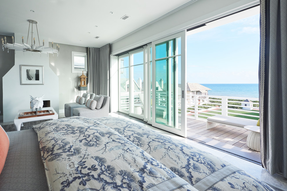 На фото: большая хозяйская спальня в морском стиле с серыми стенами, мраморным полом, стандартным камином, фасадом камина из штукатурки и серым полом с