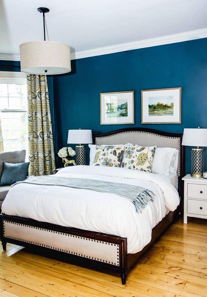 Immagine di una camera matrimoniale classica con pareti blu, parquet chiaro e nessun camino