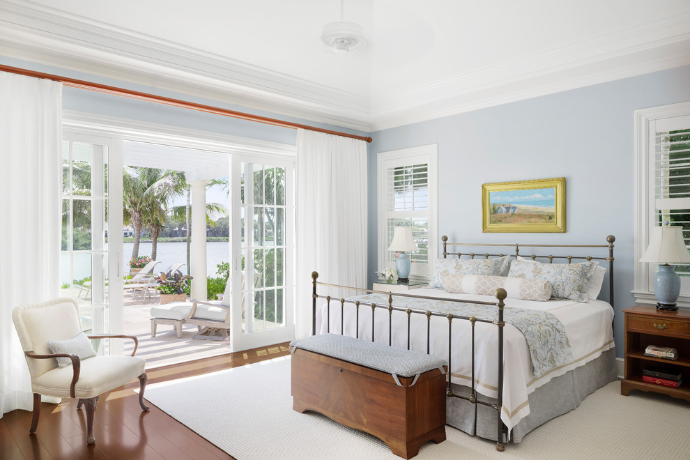 Maritimes Schlafzimmer mit blauer Wandfarbe, braunem Holzboden und braunem Boden in Miami
