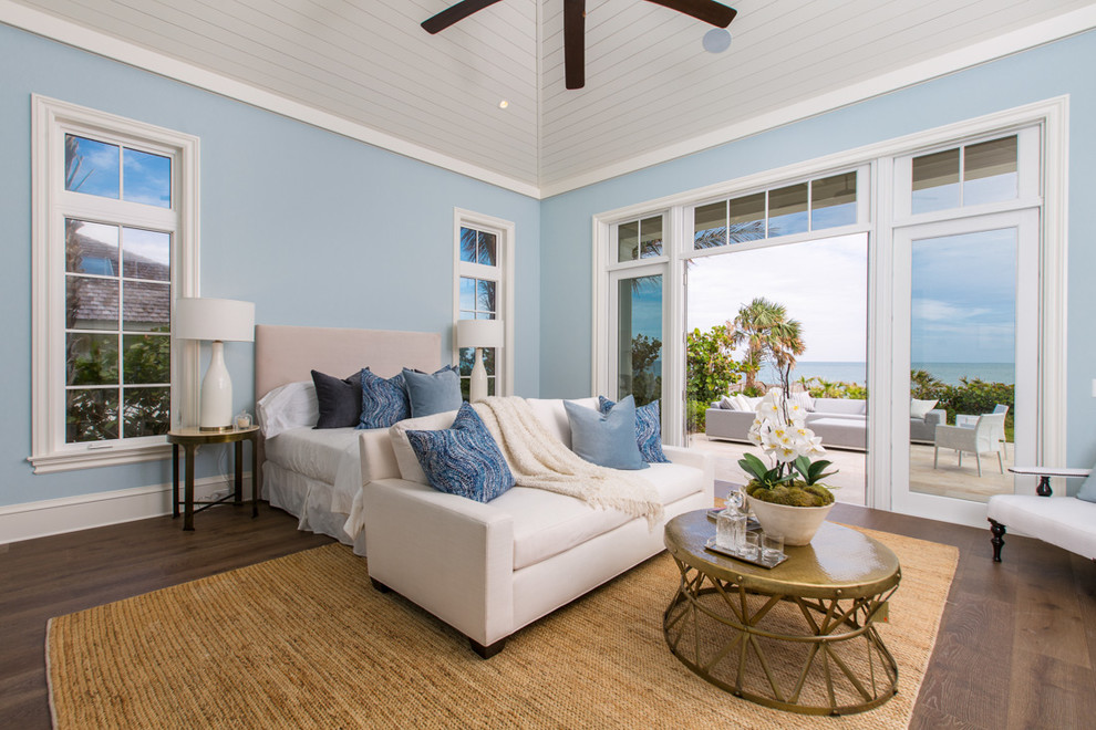 マイアミにあるビーチスタイルのおしゃれな主寝室 (青い壁、濃色無垢フローリング)