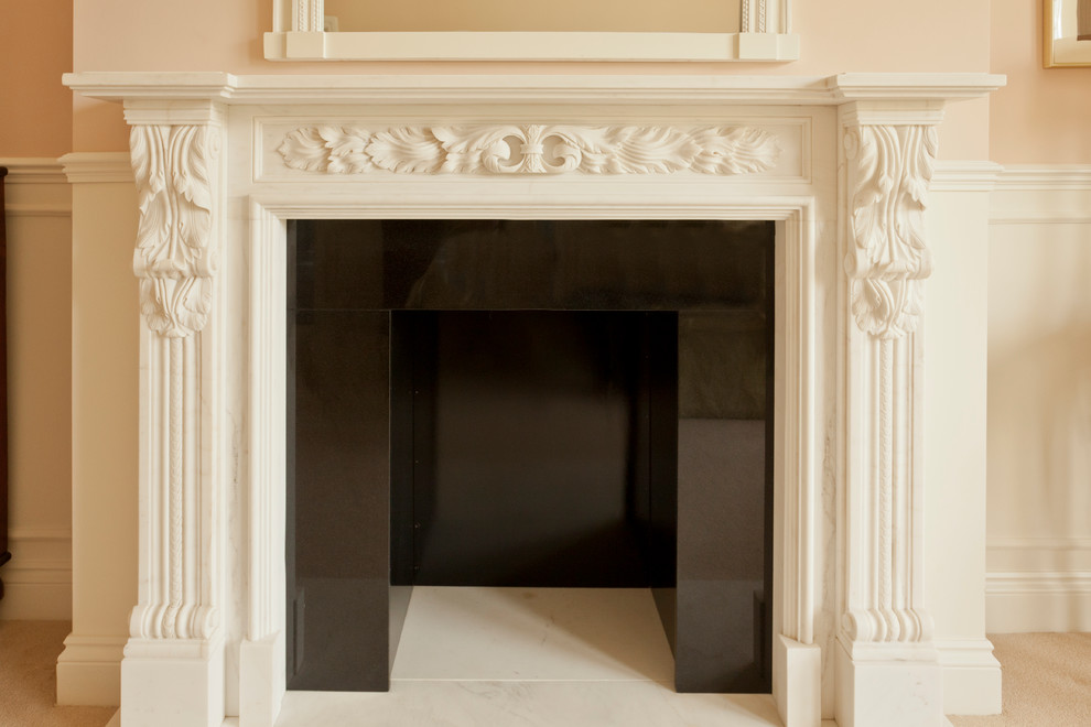 Klassisches Schlafzimmer mit Kaminumrandung aus Stein in London
