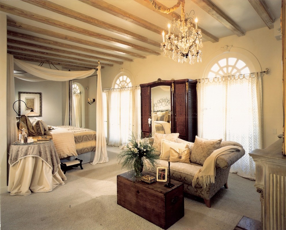 Photo of a large traditional master bedroom in San Diego with beige walls and carpet.