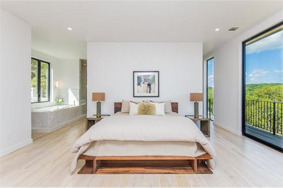 オースティンにある広いシャビーシック調のおしゃれな主寝室 (白い壁、淡色無垢フローリング、ベージュの床) のインテリア
