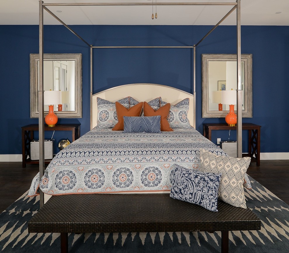 Modelo de dormitorio principal clásico renovado extra grande sin chimenea con paredes azules y suelo de madera oscura