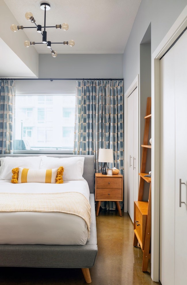 Esempio di una camera da letto minimal con pareti blu, pavimento in cemento e pavimento marrone