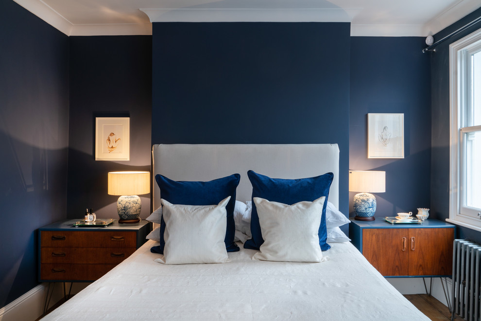 ロンドンにあるトランジショナルスタイルのおしゃれな寝室 (青い壁、濃色無垢フローリング、暖炉なし)