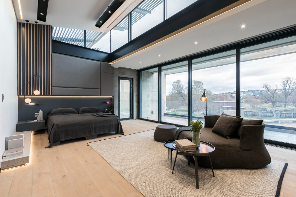 Modernes Schlafzimmer mit grauer Wandfarbe, hellem Holzboden, beigem Boden und gewölbter Decke in Sonstige