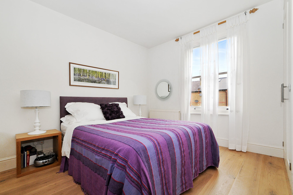 Foto de dormitorio principal costero pequeño con paredes blancas, suelo de madera clara y suelo beige