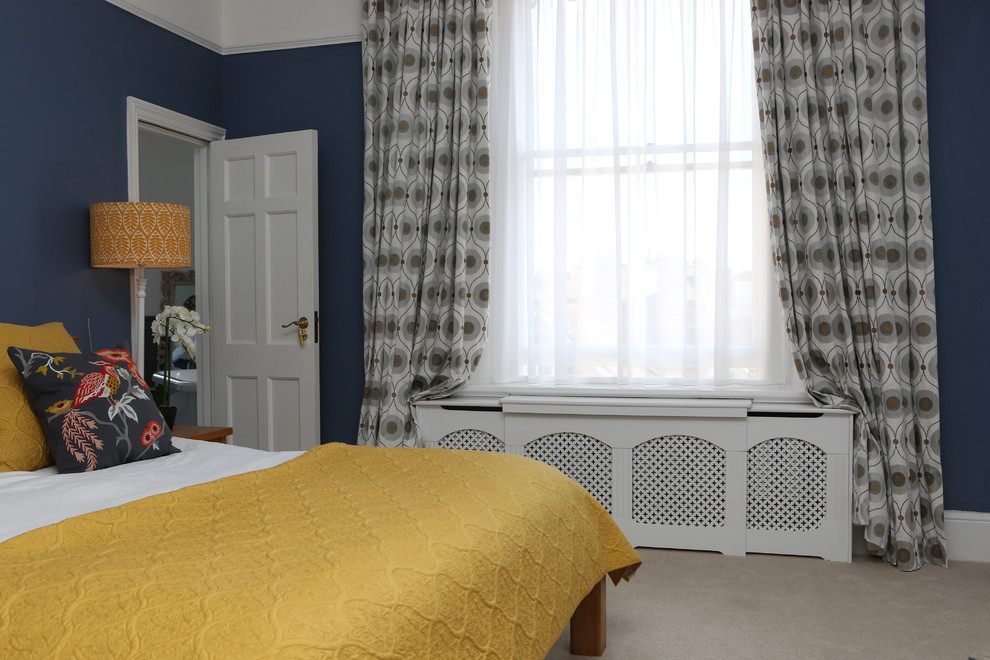 This is an example of a large classic master bedroom in Dorset with blue walls, carpet and no fireplace.