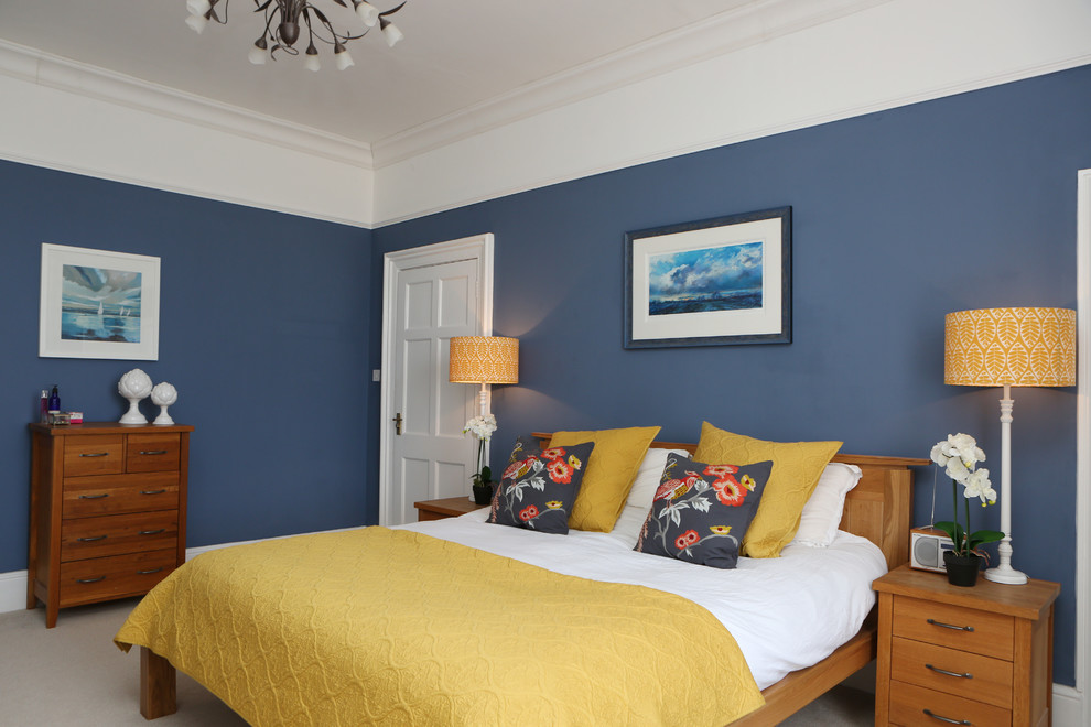 Modelo de dormitorio principal clásico grande sin chimenea con paredes azules y moqueta