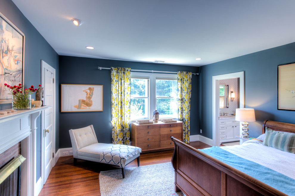 Foto de dormitorio principal de tamaño medio con paredes azules, suelo de madera clara, todas las chimeneas y marco de chimenea de ladrillo