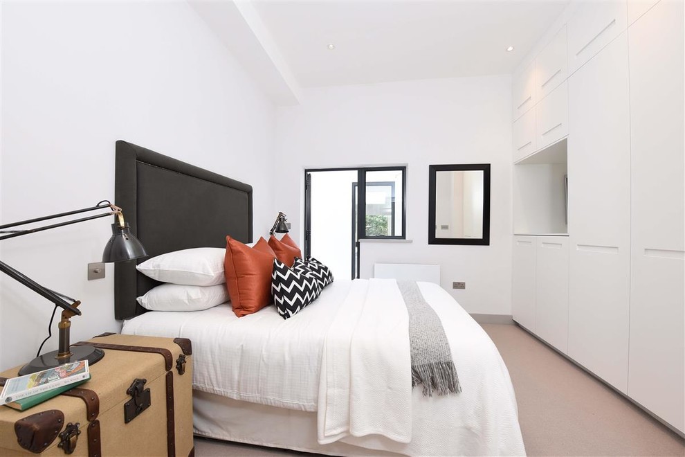 Modernes Schlafzimmer ohne Kamin mit weißer Wandfarbe und Teppichboden in London