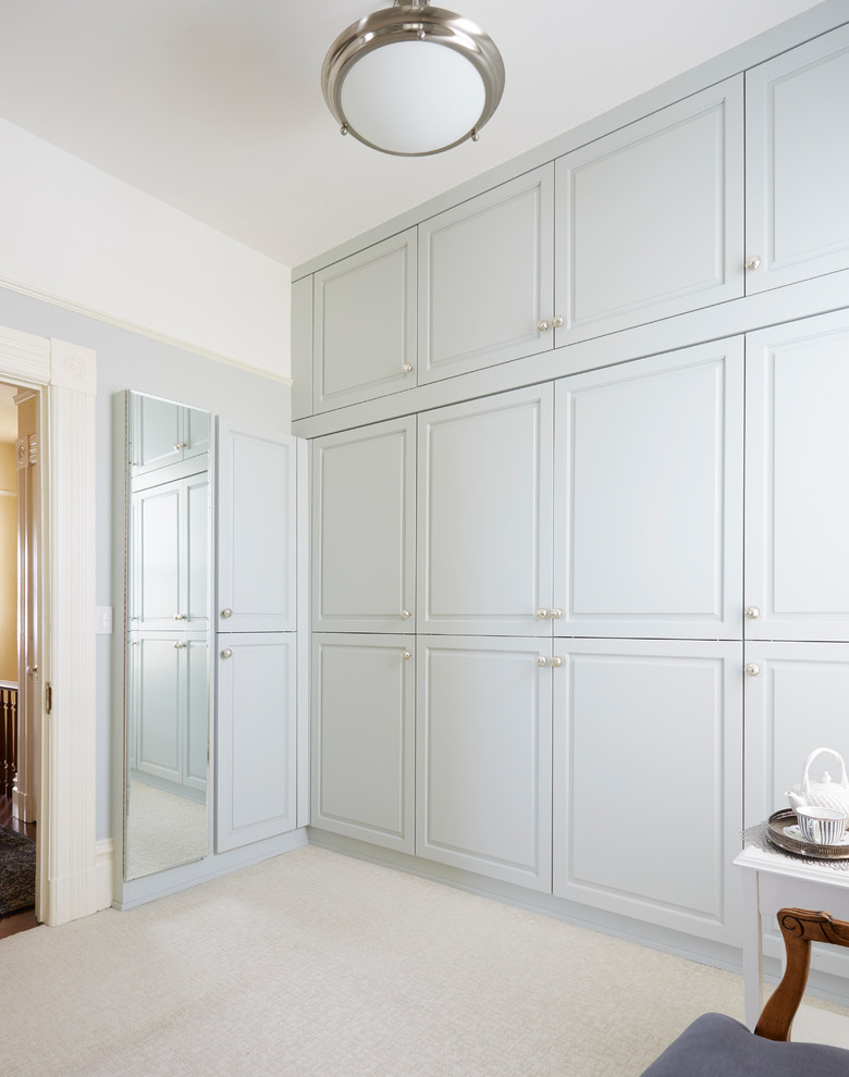 Imagen de dormitorio principal clásico grande con paredes azules, moqueta y suelo beige