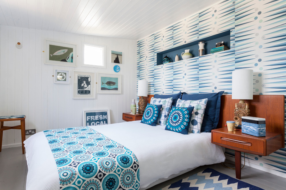 Nautical bedroom in London with white walls, painted wood flooring and a feature wall.