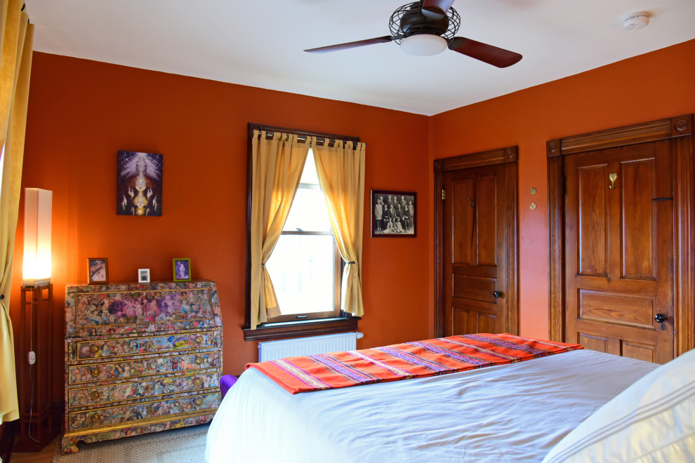 Cette photo montre une chambre victorienne avec un mur orange, parquet clair et aucune cheminée.